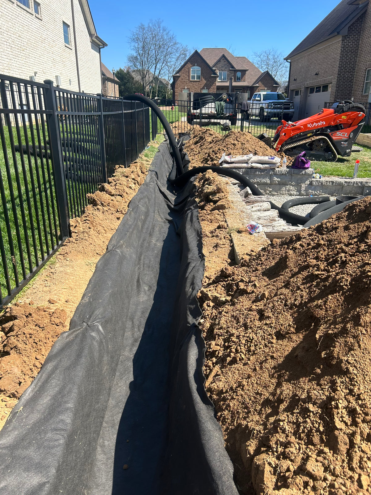 French drain trench with fabric and pipe installed on a residential LPSI job